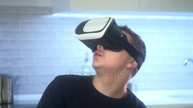 Adam Vr kulaklık giyen mutfak at. Hareketleri el ile kullanarak.
