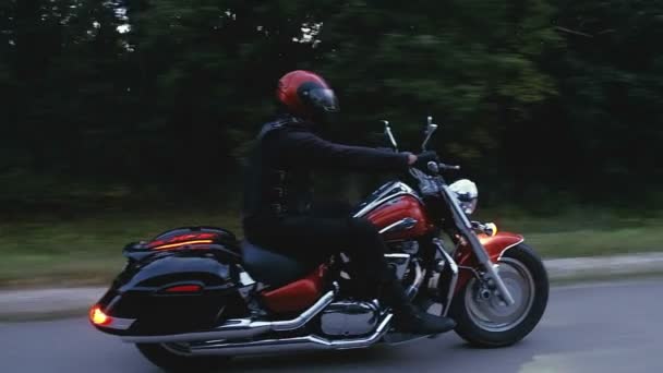 Een man rijdt een motorfiets een weg in bos — Stockvideo