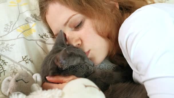 Mano di una donna anziana accarezzando gatto grigio che dorme sul letto — Video Stock