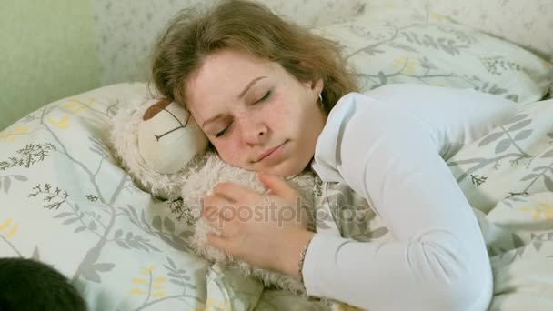 Mão de uma mulher idosa acariciando gato cinza dormindo na cama — Vídeo de Stock