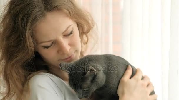 Giovane donna con il suo bel gatto grigio, sfondo bianco — Video Stock