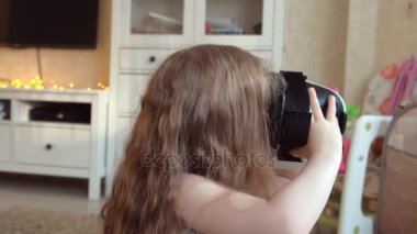 VR kulaklık giyen küçük kız beyaz gömlek izlerken 360 video evde,.