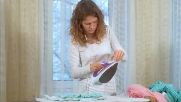 Attraktive und schöne Frau bügelt Kleidung zu Hause — Stockvideo