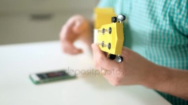Bir adam telefonda uygulama kullanarak ukulele ayarlar