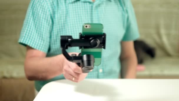 Чоловік налаштовує тривісний стабілізатор для телефону — стокове відео