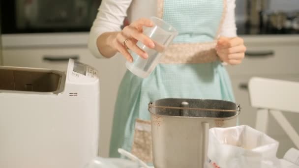 Una mujer en la cocina prepara pan en una máquina de hacer pan — Vídeos de Stock