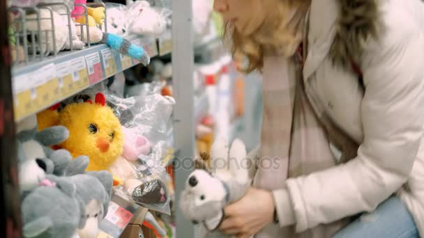 Uma jovem mulher fazendo compras escolhe os bens no supermercado no departamento para crianças — Vídeo de Stock