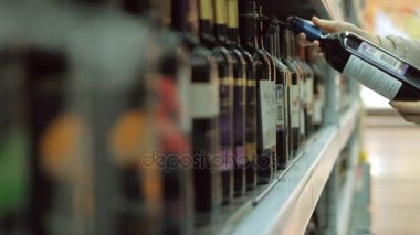 Bir süpermarkette genç bir kadın şarap satın alır.