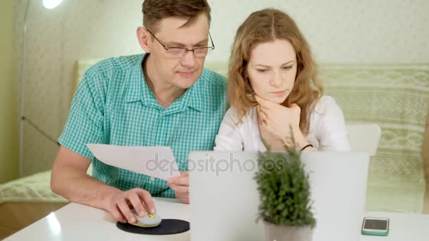 Sourire jeune couple à l'aide d'un ordinateur portable à la maison discuter émotionnellement — Video