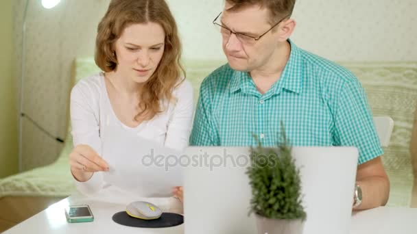 Sorrindo jovem casal usando laptop em casa emocionalmente discutir — Vídeo de Stock