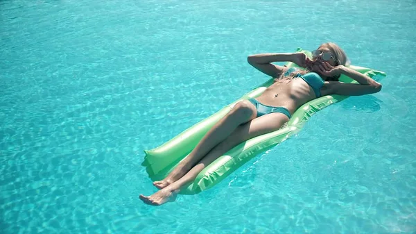 Молодая красивая женщина лежит на надувном матрасе в бассейне — стоковое фото