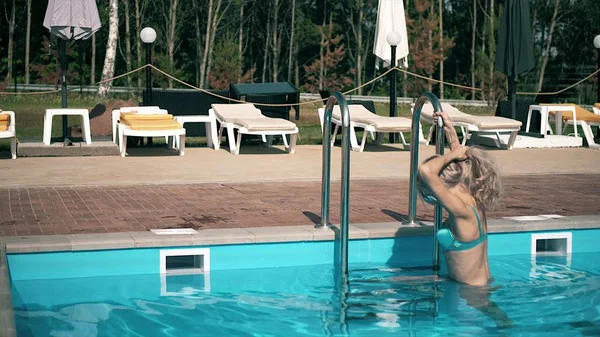 Uma mulher bonita relata uma piscina a nadar com águas pretas. — Fotografia de Stock
