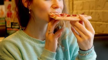 Bir restoranda pizza yemek ve çay içme genç güzel kadın