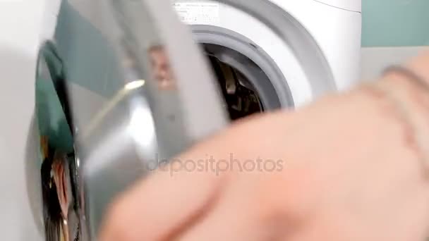 Huisvrouw vult wasmachine van wasmand en sloten machine deur — Stockvideo