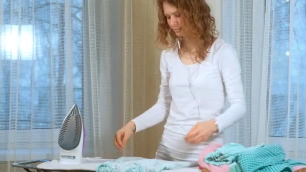 Attractive and beautiful woman ironing clothes at home — Stock Video