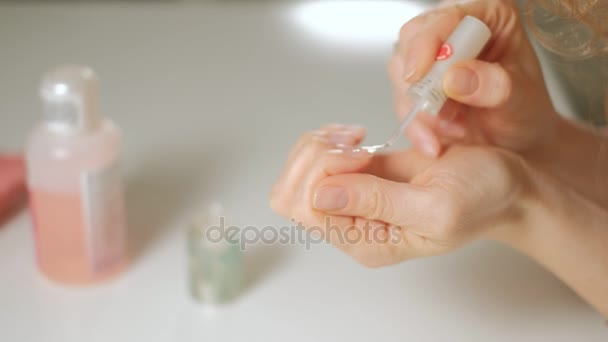 Uma mulher faz sua própria manicure em suas mãos em casa — Vídeo de Stock