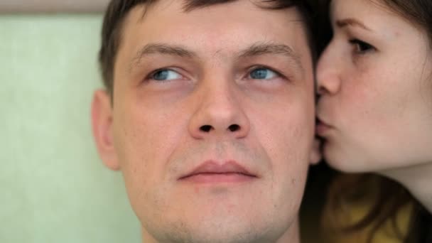 Женщина шепчет мужчинам на ухо, эмоции на лице — стоковое видео