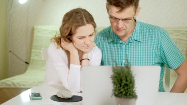 Mosolygó fiatal pár használ laptop otthon érzelmileg megvitatása — Stock videók