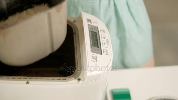 Una mujer en la cocina prepara pan en una máquina de hacer pan — Vídeos de Stock