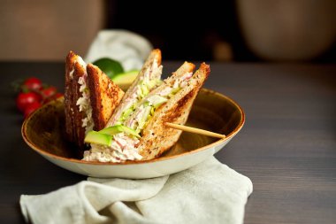 Tahta arka planda marul, jambon, peynir ve domatesli sağlıklı sandviç tostu.