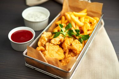 tavuk nuggets kızartması ve ahşap tahta üzerinde farklı sos ile,