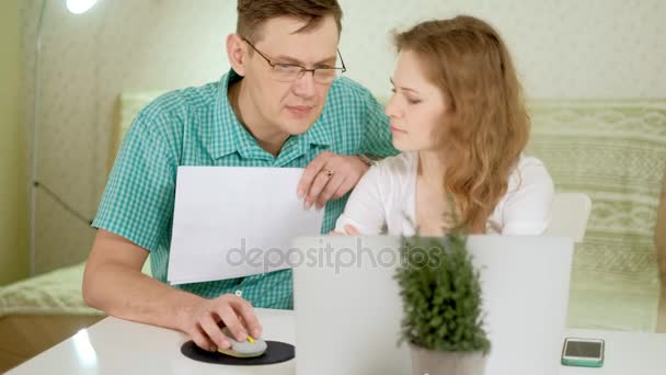 Συζητήστε χαμογελώντας νεαρό ζευγάρι που χρησιμοποιούν φορητό υπολογιστή στο σπίτι συναισθηματικά — Αρχείο Βίντεο