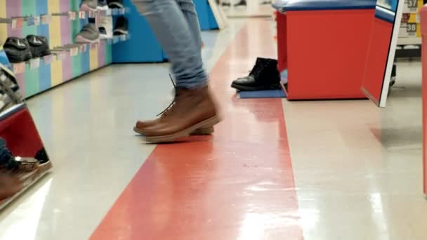 Kobieta w sklepie obuwniczym wybiera buty stara — Wideo stockowe