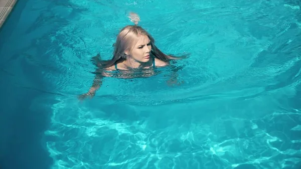 Ung vacker kvinna liggande på luftmadrass i poolen — Stockfoto