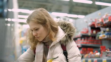 Çocuklar için bölümünde süpermarkette malları alışveriş genç bir kadın seçer
