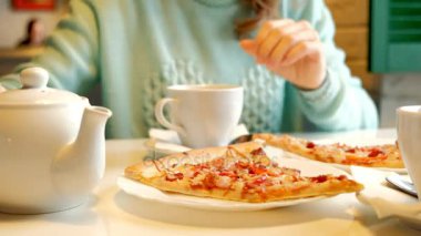 Bir restoranda pizza yemek ve çay içme genç güzel kadın