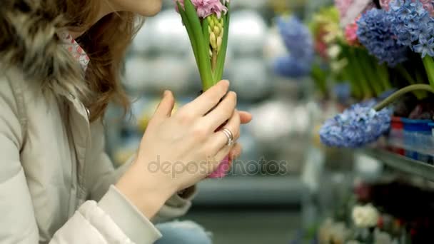 Μια νεαρή γυναίκα σε ένα σούπερ μάρκετ αγοράζει λουλούδια — Αρχείο Βίντεο
