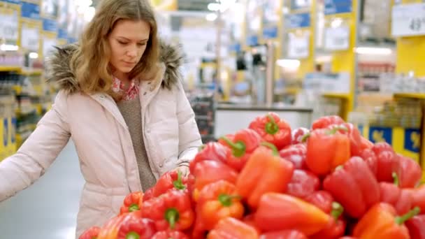 Egy fiatal nő, egy szupermarketben vásárol piros paprika — Stock videók