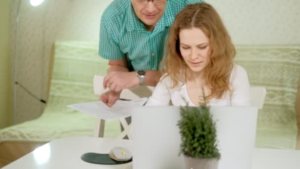 Sorrindo jovem casal usando laptop em casa emocionalmente discutir — Vídeo de Stock