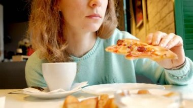 Bir restoranda pizza yemek ve çay içme genç güzel kadın