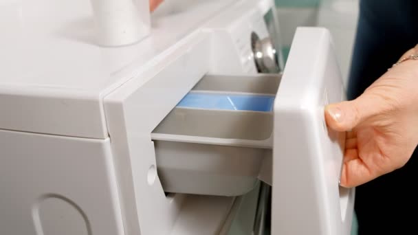 Frau füllt Fach in Waschmaschine mit Waschmittel aus und schließt Schublade — Stockvideo
