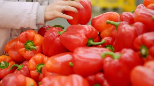 Una joven en un supermercado compra pimiento rojo — Vídeos de Stock