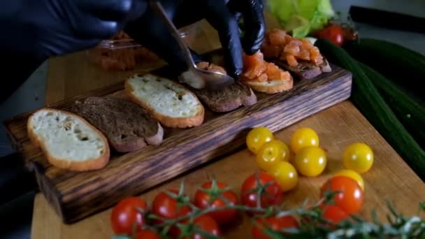 Людина підготовка італійський Брускетта з запечений помідорів, базилік, сиру. Італійська кухня повільний рух — стокове відео