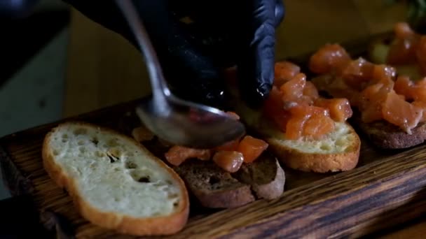 Людина підготовка італійський Брускетта з запечений помідорів, базилік, сиру. Італійська кухня повільний рух — стокове відео