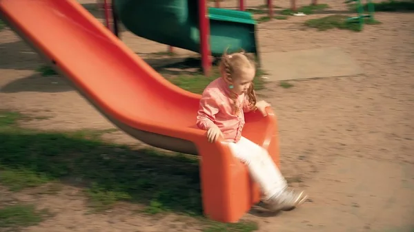 Kind rutscht im Park auf Rutsche, kleines Mädchen spielt auf Spielplatz, Kinder — Stockfoto