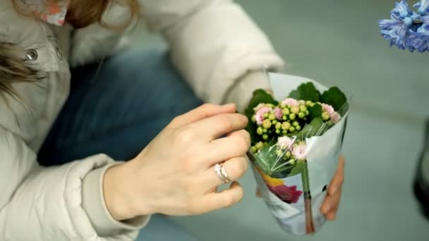 Een jonge vrouw in een supermarkt koopt bloemen — Stockvideo