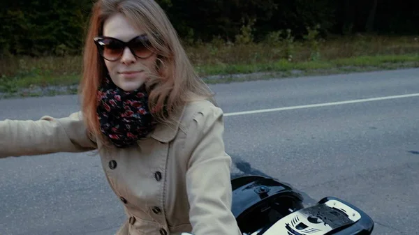 갈색 머리를 가진 어린 소녀는도 근처 오토바이에 앉아. — 스톡 사진