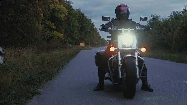 Mann fährt mit Motorrad eine Straße im Wald hinunter — Stockfoto