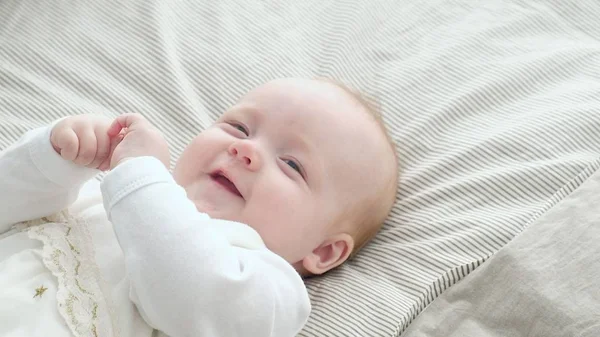Счастливый ребенок катается на кровати — стоковое фото