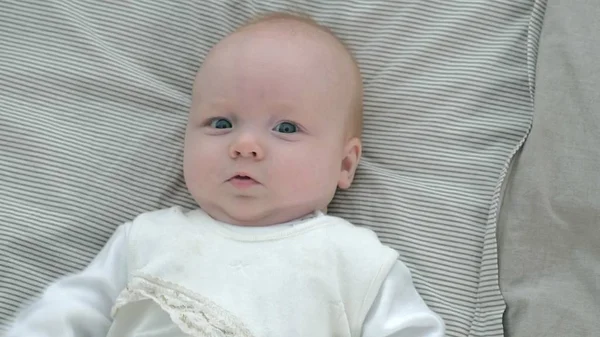 Feliz bebê rolando na cama — Fotografia de Stock