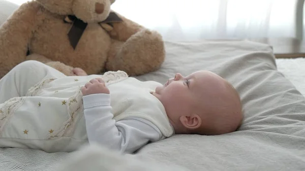 Bébé heureux roulant sur le lit — Photo