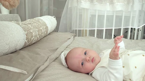 Bébé heureux roulant sur le lit — Photo