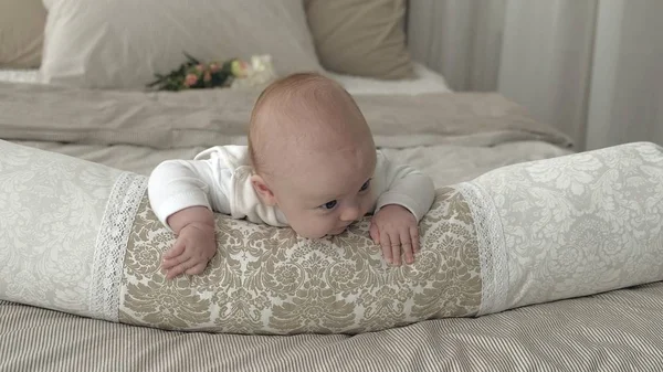 Boldog baba gördülő az ágyon — Stock Fotó