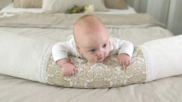 Happy baby rollen op het bed — Stockfoto