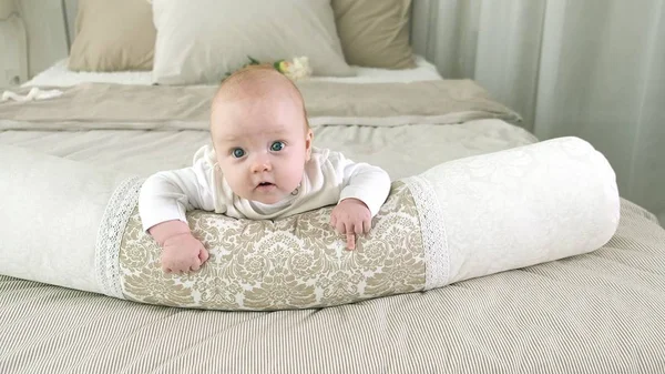 Счастливый ребенок катается на кровати — стоковое фото
