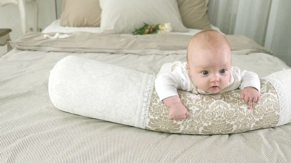 Bébé heureux roulant sur le lit — Photo